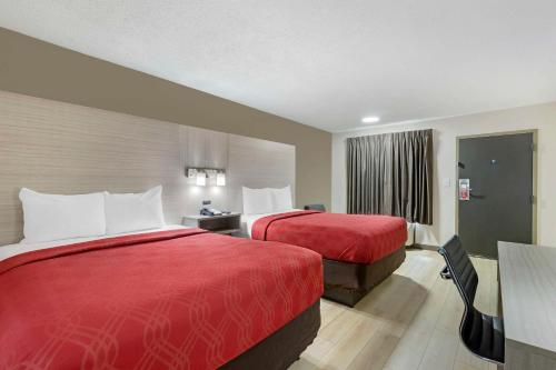 奥古斯塔Econo Lodge Augusta, Downtown的酒店客房设有两张床和一张桌子。