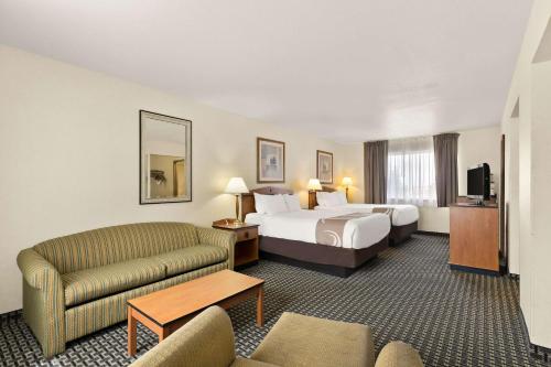 夏延Quality Inn Cheyenne I-25 South的酒店客房,配有床和沙发