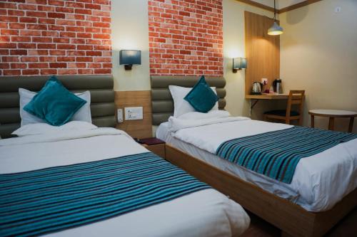 拉杰果德HOTEL EVERLAND的酒店客房带两张床和砖墙