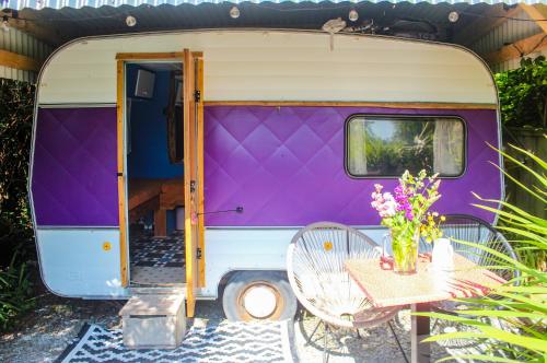 瓦伦西亚岛Retro Caravans at Valentia Island Escape的紫色和白色的大篷车,配有桌椅