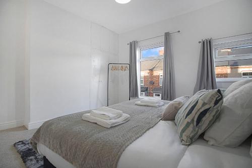 达灵顿Peaceful Dwelling at Falmer Road, Sleeps 4的白色卧室,配有带毛巾的床