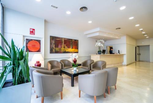 巴塞罗那格洛雷耶斯酒店的一间诊所的等候室,配有椅子和桌子
