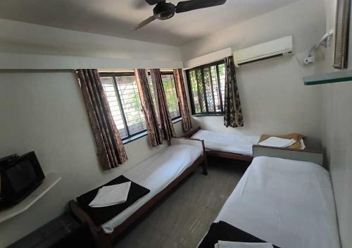孟买Hotel Rupali的小房间设有两张床和电视