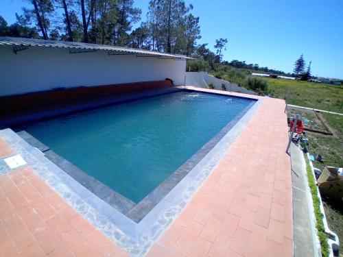 维拉·雷阿尔·德·桑托亚UFitness Hotel的一座带房子的庭院内的大型游泳池