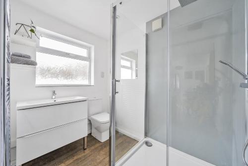海尔Waters Edge Holiday Home in Hayle, West Cornwall的白色的浴室设有水槽和淋浴。