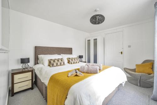 海尔Waters Edge Holiday Home in Hayle, West Cornwall的白色卧室配有一张大床和椅子