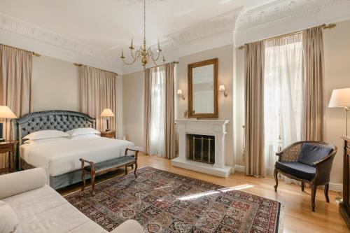 雅典贵族套房公寓式酒店的一间卧室配有一张床和一个壁炉
