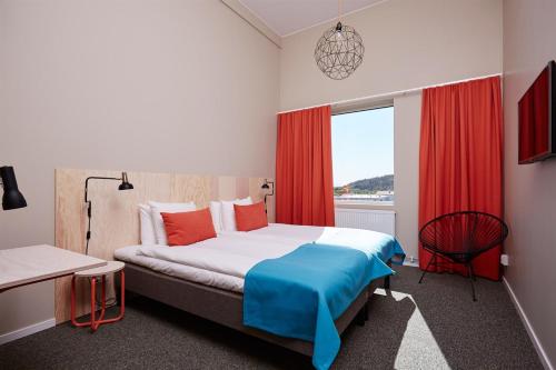 哥德堡Kviberg Park Hotel & Conference的一间卧室配有一张带红色窗帘的床和一扇窗户