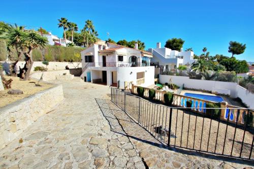 莫莱拉Droomland - sea view villa with private pool in Moraira的一座带游泳池和围栏的房子