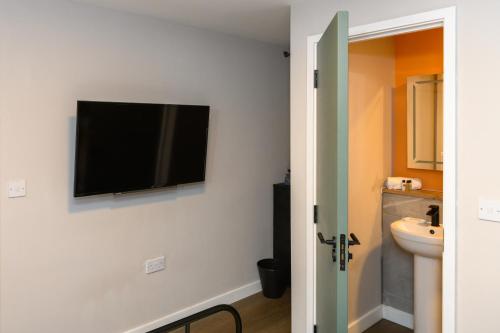 卡迪夫Gad Suite by Koya Homes - Cardiff City Centre Location!! 2 En-suites的墙上设有1间带平面电视的浴室