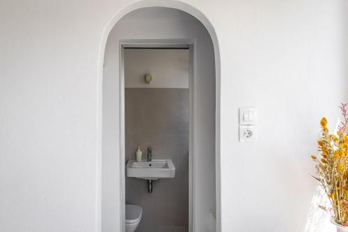 苏尼翁Renovated Seaside Cabin in Sounio的白色的浴室设有水槽和卫生间。