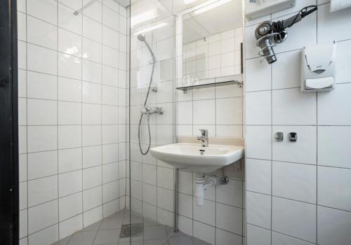 克里斯蒂安桑德Thon PartnerHotel Storgata的白色的浴室设有水槽和淋浴。