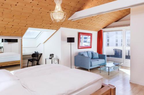 迪本多夫索雷尔索内塔尔酒店的卧室配有白色的床和蓝色的沙发