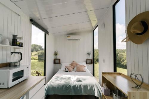 库兰达Rainforest Sunsets的一间卧室设有一张床和一个大窗户