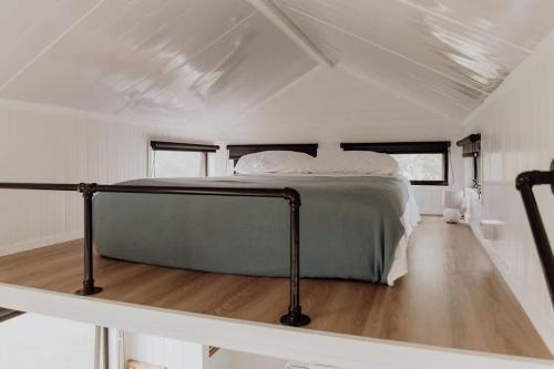 PerwillowenHill Creek Tiny House的白色客房中间的一张床