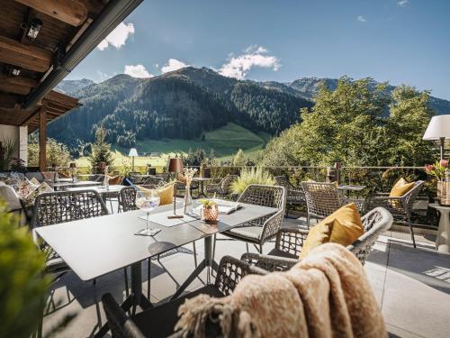 希帕赫Hotel Bergkristall Zillertal的一个带桌椅的山景庭院
