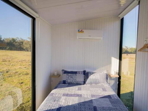 库纳巴拉布兰Little Argyle Tiny House的一间卧室设有一张床和一个大窗户