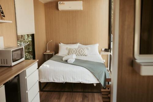 PalmwoodsThe Stables的一间小卧室,配有一张床和一台微波炉