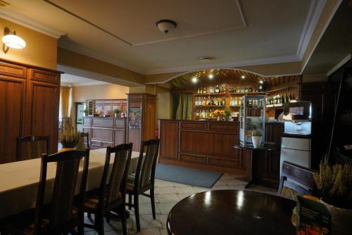 OlesnoHotel Alexandra的餐厅设有酒吧,配有桌椅