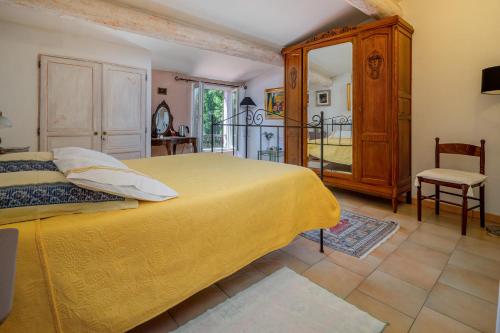 洛里Clos des Hérissons - Chambres - Piscine & jardin的一间卧室设有一张黄色的床和一个阳台