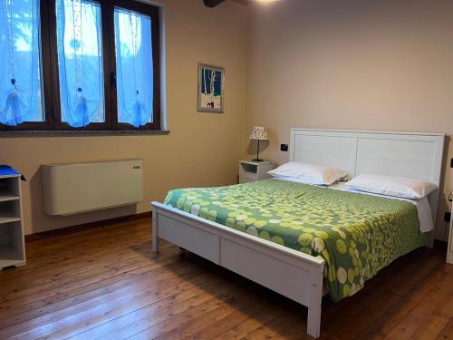卡内利维奇奥托奇奥农家乐的一间卧室配有一张带绿色和黄色毯子的床