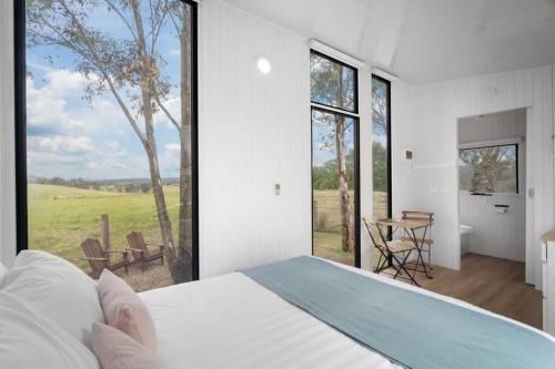 BuchanThe Stockmans Camp 1 - Sunset Tiny House的一间卧室设有一张床和一个大窗户
