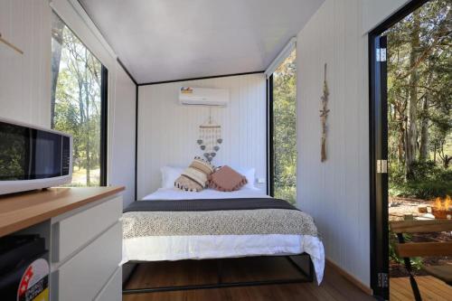 Silveroak Lodge Tiny House的一间小卧室,配有床和窗户
