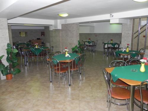克卢日-纳波卡珍布鲁酒店的用餐室配有绿色的桌椅
