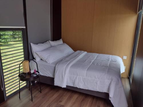 劳勿Sungai Tiny House 2的一间卧室配有一张床、一张桌子和一个窗户。