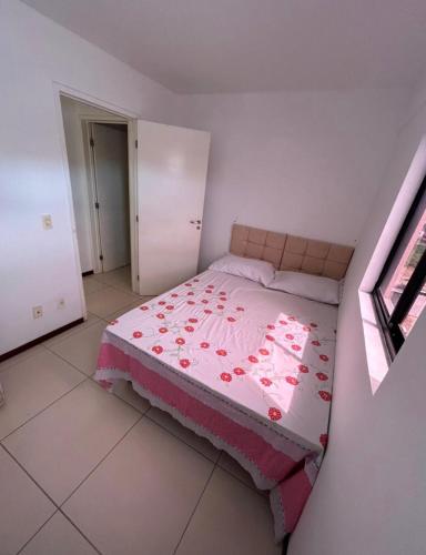 马塞约Apartamento próximo a praia的一间卧室配有一张带粉红色棉被的床