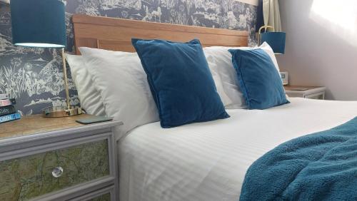 温德米尔Invergarry Room Only Guest House For Adults的一间卧室配有一张带蓝色和白色枕头的床