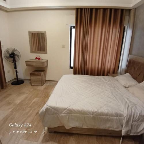 安曼Alqaisi Group的一间卧室设有一张床、一个窗口和风扇