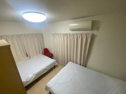 东京tokyo Large family vacation rentals的小房间设有两张床和一盏灯