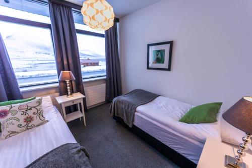 ÓlafsfjörðurThe Northern Comfort Inn的一间卧室设有两张床和窗户。