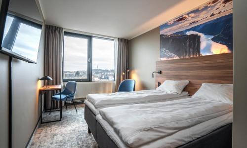 斯塔万格Thon Partner Stavanger Forum Hotel的酒店客房设有一张床、一张书桌和窗户。