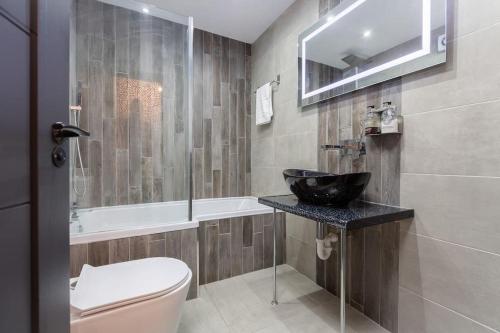 布莱克浦2bdr house - close to seafront的浴室配有盥洗盆、卫生间和浴缸。