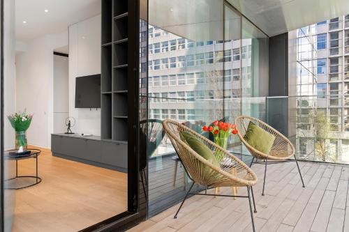布加勒斯特ONE Luxury Apartments的一间设有两把椅子和一张桌子及电视的房间