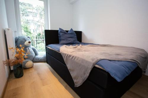 杜伊斯堡Traumhafte Stadtwohnung的卧室配有一张带泰迪熊的床,毗邻窗户