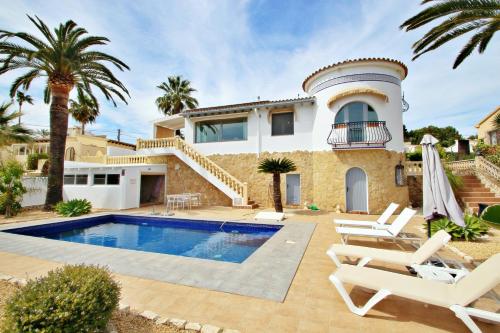 莫莱拉Golondrina - panoramic hillside holiday house in Moraira的一座别墅,设有游泳池和棕榈树