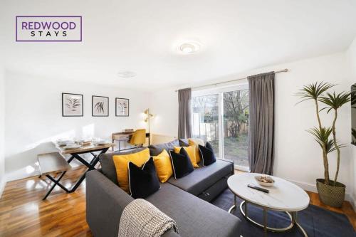 法恩伯勒Cozy 3 Bed House with X2 FREE Parking By REDWOOD STAYS的客厅配有蓝色的沙发和黄色的枕头。