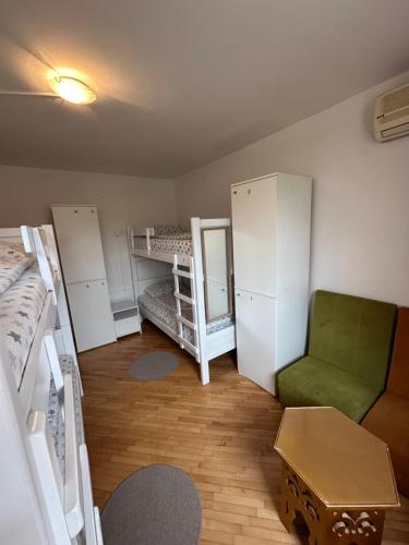 萨拉热窝One Love的客房设有两张双层床和一张绿色椅子。