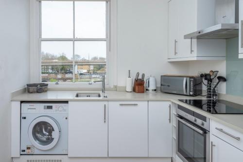 伦敦BRAND NEW The Palms: Luxury Family Residence的白色的厨房配有洗衣机和窗户。