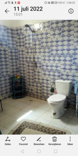 姆布尔Chambre espacée et lumineuse的一间带卫生间和瓷砖墙的浴室