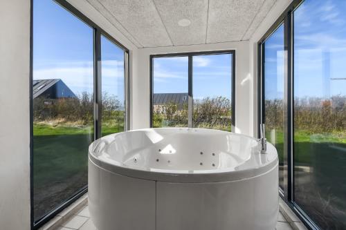 莱姆维Pool house with beautiful view by the sea - SJ650的窗户客房内的白色大浴缸