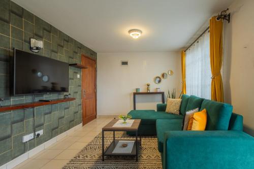 内罗毕Furnished 1 Bedroom Apartment in Nairobi. 15 Mins to CBD. Free WI-FI & Parking的客厅配有绿色沙发和电视