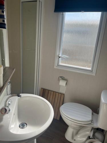 帕兹托Saltsea的一间带水槽和卫生间的浴室以及窗户。