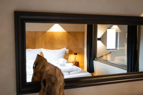温特贝格SAUERLAND CHALETS - "Die Chalets Herzenssache"的镜子反射在酒店房间的床