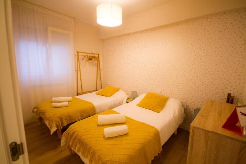 埃尔穆阿Piso reformado en el centro de Euskadi的配有两张黄色和白色床单的床铺