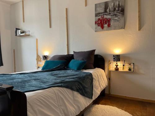维桑堡Appartements « La Parenthèse »的一间卧室配有一张带蓝色枕头的大床