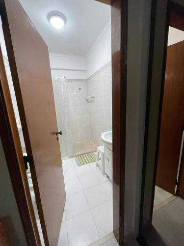 阿尔马达Quarto Suite Relaxante的带淋浴、卫生间和门的浴室